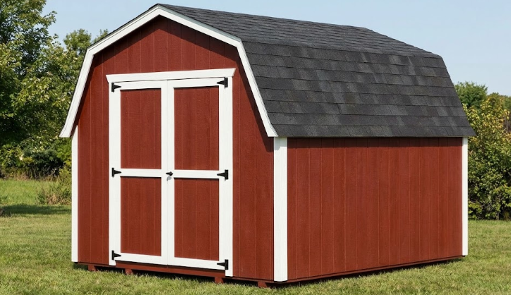 Red 10x12 barn-style shed with a gambrel roof and white trim in a grassy field.